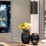 Offener Wohn Essbereich mit Küche Kochinsel Vasen Blumen Schwarz Marmor