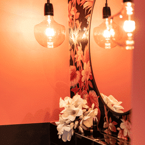 Interior Design Badezimmer Inspiration orangenes Bad florale Tapete runder Spiegel Blumen