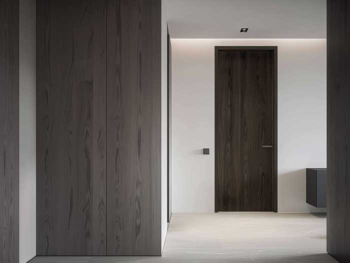 Minimalistischer Flur mit flächenbündiger dunkler Holztür – moderne Hausbau Inneneinrichtung mit klarer Linienführung.