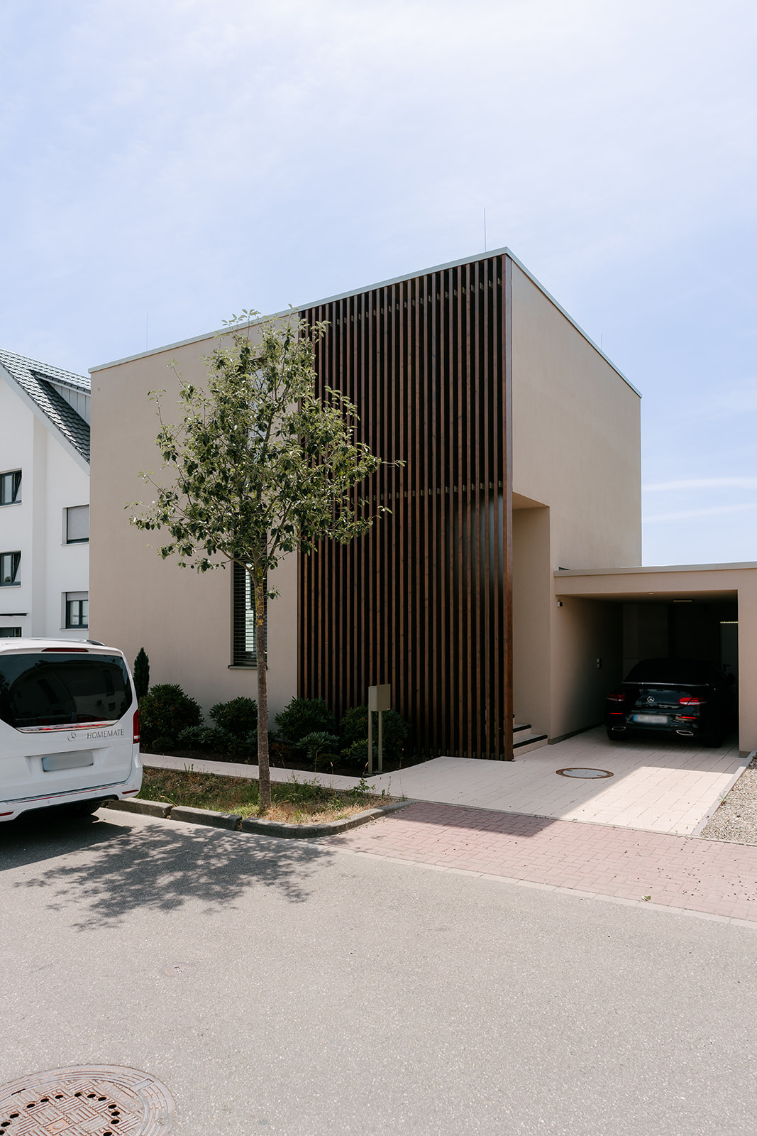 Frontansicht einer modernen Hausfassade mit verbindenden vertikalen Lamellen