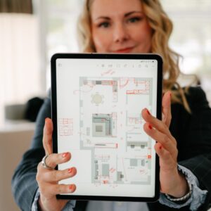 Monika Winden zeigt einen farbig angelegten Grundriss auf dem Tablet, Grundriss-Check