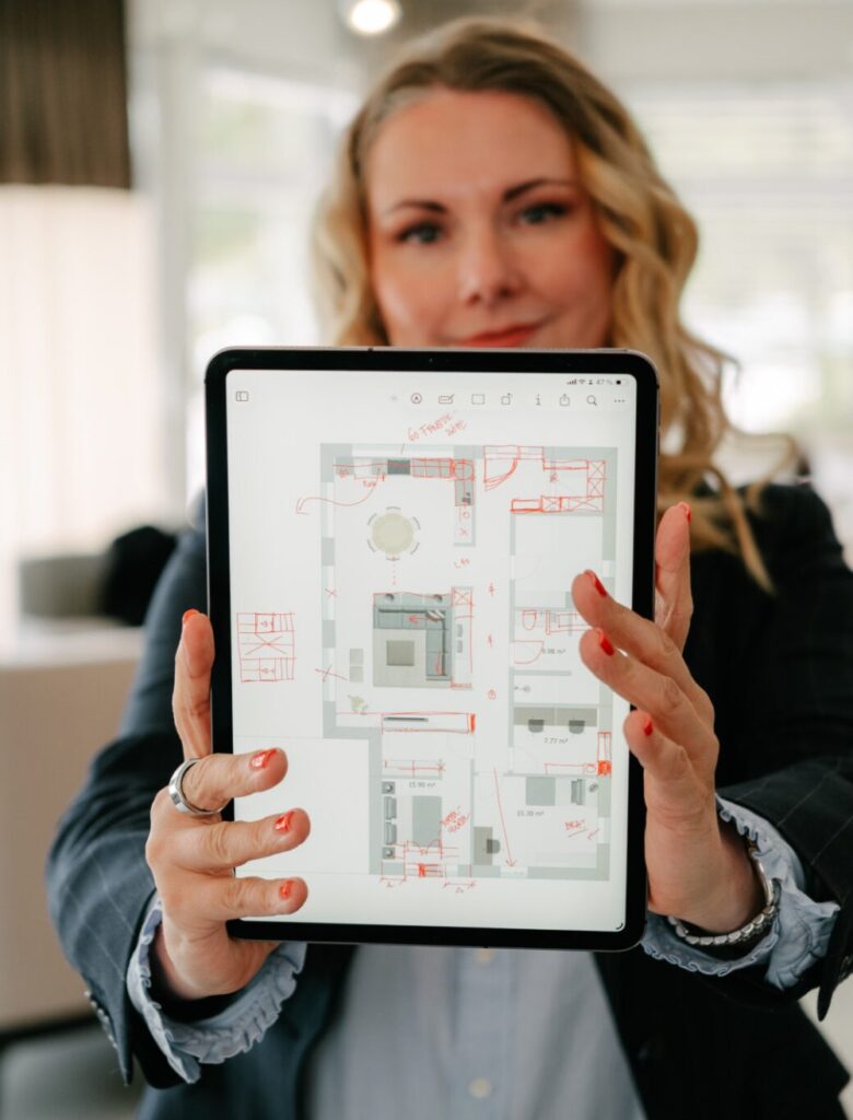 Monika Winden zeigt einen farbig angelegten Grundriss auf dem Tablet, Grundriss-Check